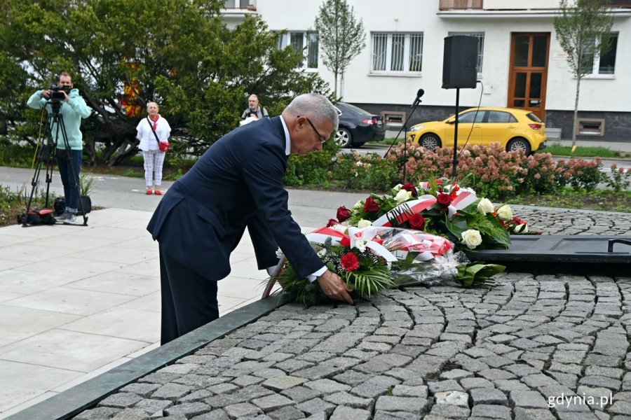 Krzysztof Dośla, przewodniczący zarządu regionu gdańskiego NSZZ „Solidarność” składający kwiaty przed pomnikiem Ofiar Grudnia 1970 roku na placu Wolnej Polski podczas obchodów 43. rocznicy strajków sierpniowych i podpisania porozumień sierpniowych. W tle zieleń, kwiaty, samochody i budynki // fot. Magdalena Czernek