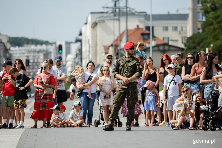 Mieszkańcy miasta na pierwszym planie żołnierz w mundurze