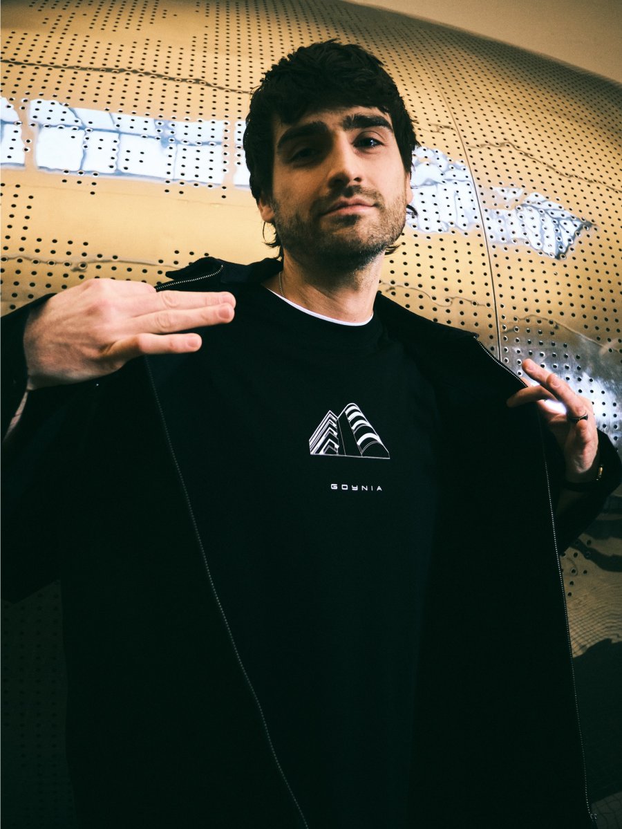 W kolekcji marki Diverse pojawiły się longsleevy, kt&oacute;re prezentuje model na tle sfery Muzeum Emigracji w Gdyni