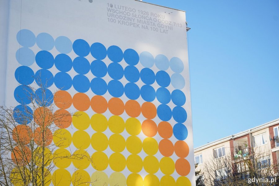 Kolorowe koła na ścianie jednego z blok&oacute;w na Karwinach układające się we wsch&oacute;d słońca nad morzem