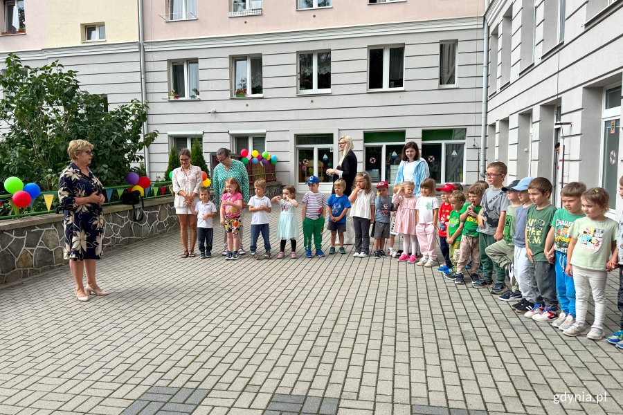 Dzieci i nauczyciele z przedszkola na taresie budynku 