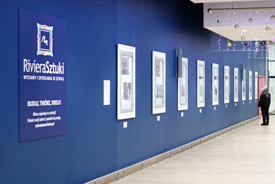 Wystawa podsumowująca cykl „Wtorki z Rodzinnymi” jest prezentowana w Centrum Riviera. Rząd plansz ze zdjęciami, które wiszą na niebieskiej ścianie "Riviery Sztuki" // fot. materiały prasowe