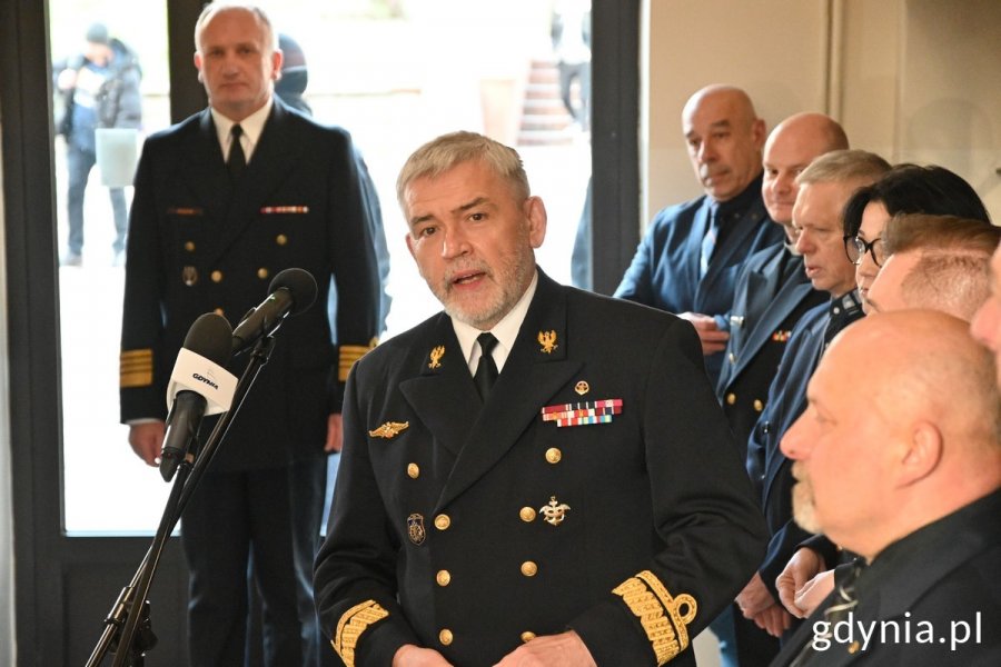 na zdjęciu mężczyzna z siwą brodą w mundurze, przy mikrofonie