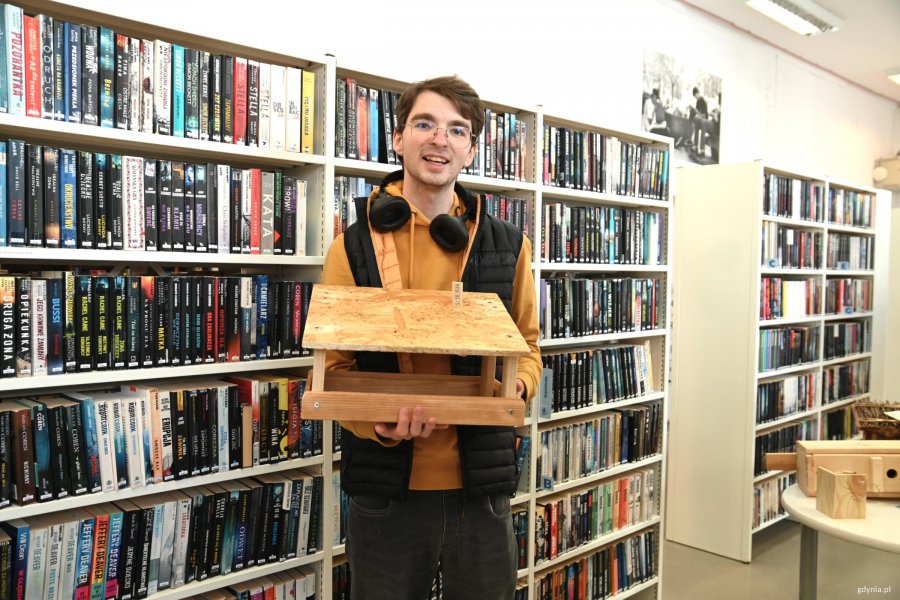 Młody mężczyzna z karmnikiem i słuchawkami na uszach