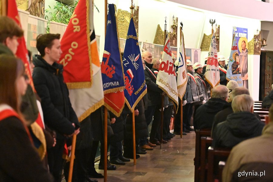 Poczty sztandarowe ustawione w rzędzie w kościele pw. Matki Bożej Nieustającej Pomocy i św. Piotra Rybaka podczas obchodów 42. rocznicy wprowadzenia stanu wojennego