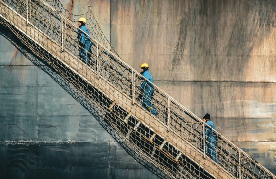 Trzej mężczyźni wchodzący po trapie na statek