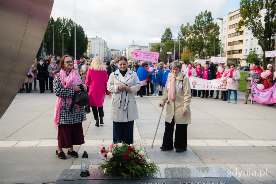 Prezydent Gdyni Aleksandra Kosiorek i Janina Łojba – prezes Stowarzyszenia Amazonek Gdyńskich składające kwiaty pod pomnikiem Polski Morskiej podczas Marszu Różowej Wstążki 