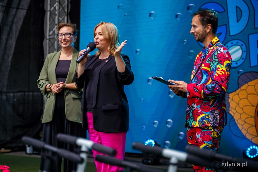 Przemówienie wiceprezydentki Gdyni Oktawii Gorzeńskiej (w środku), obok Pomorska Wicekurator Oświaty Jolanta Jankowska-Żmich i prowadzący Szymon Jachimek (fot. Kamil Złoch)