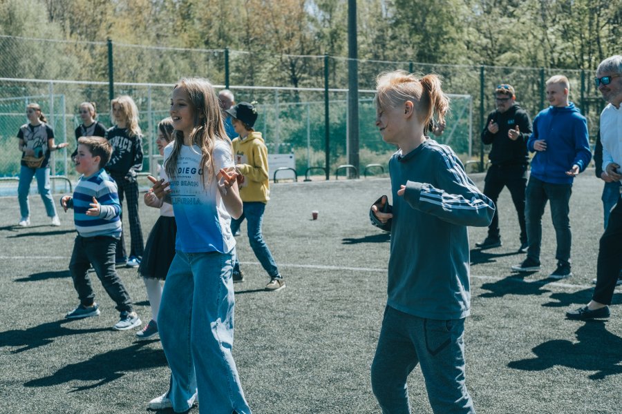 Zumba na boisku szkolnym, na pierwszym planie dwoje nastolatków