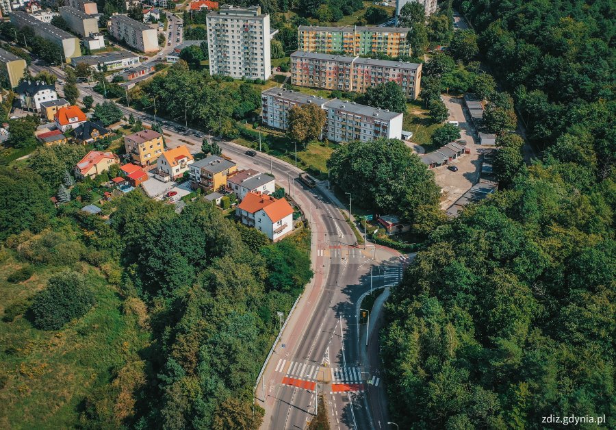 widok z góry na ulicę, w tle ruch uliczny, budynki i zieleń, widok z góry na miasto