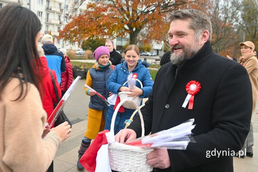 Mężczyzna przekazujący kobiecie polską flagę