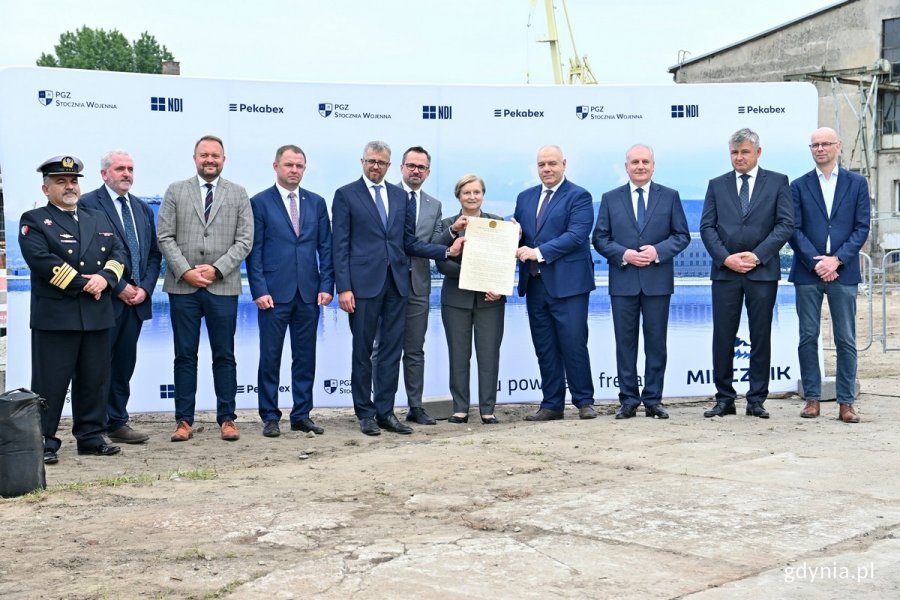 Akt erekcyjny, mówiący budowie hal stoczniowych, który włożono do kapsuły czasu, podpisali (od lewej): kmdr Piotr Skóra - szef Szefostwa Techniki Morskiej w Agencji Uzbrojenia, Sean Donaldson – dyrektor zarządzający stoczni w Rosyth należącej do firmy Babcock International, Marek Łucyk - wiceprezydent Gdyni ds. rozwoju, Marcin Wierzchowski – członek zarządu Polskiej Grupy Zbrojeniowej, Paweł Lulewicz - prezes zarządu PGZ Stoczni Wojennej, Marcin Horała - sekretarz stanu w Ministerstwie Funduszy i Polityki Regionalnej, Anna Fotyga - europosłanka, Jacek Sasin - wicepremier i minister aktywów państwowych, Dariusz Drelich - wojewoda pomorski, Marcin Lewandowski – członek zarządu spółki NDI oraz Przemysław Borek – członek zarządu spółki Pekabex Bet // fot. Magdalena Czernek