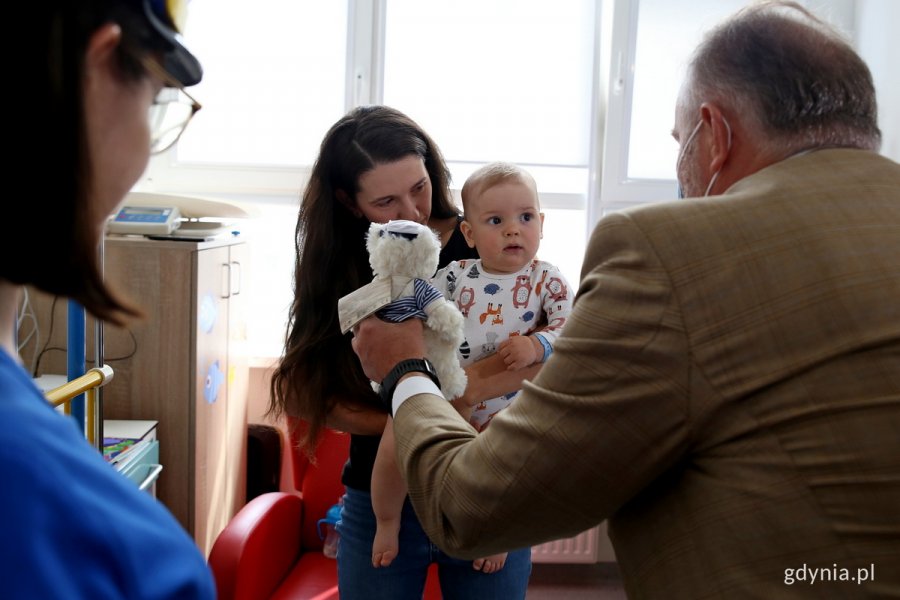 W pokoju szpitalnym stoi prezydent Gdyni oraz mama z małym dzieckiem na rękach.