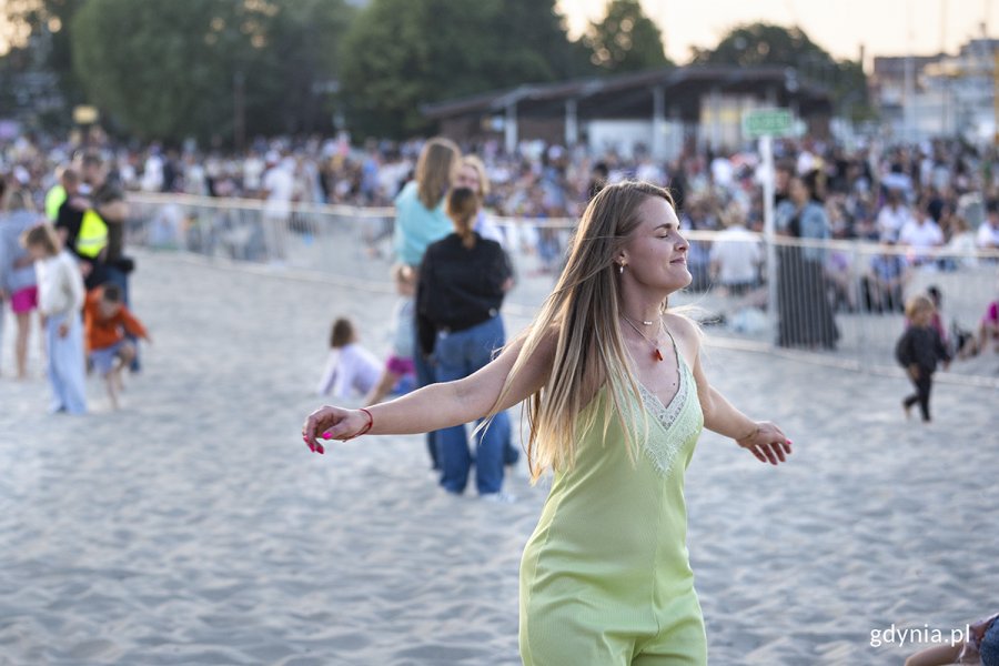 Kobieta tańczy na plaży.