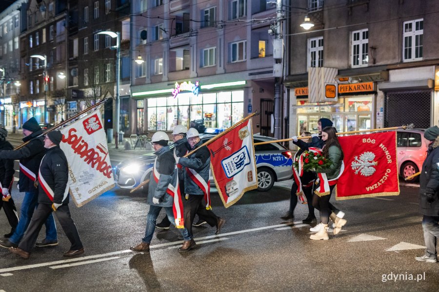 Ludzie w odświętnych strojach idący ulicą