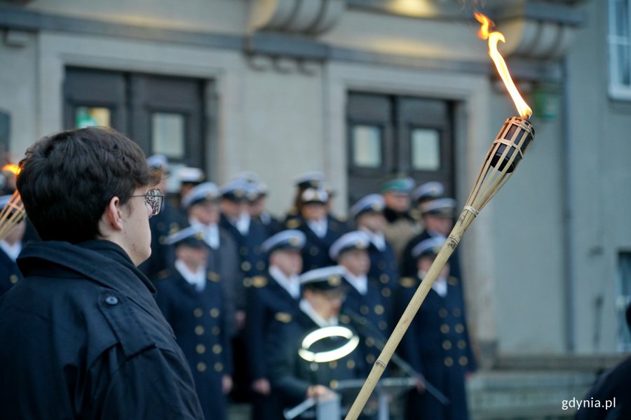 Student z pochodnią podczas apelu pamięci 
