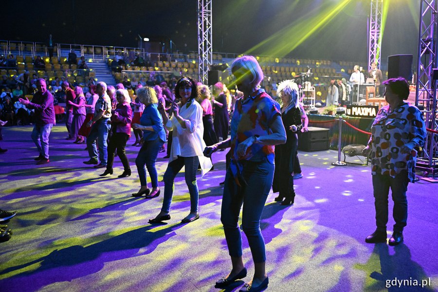 Hala Polsat Plus Arena Gdynia, scena, niebieskie światło, kolorowe oświetlenie, grupa seniorów tańczy