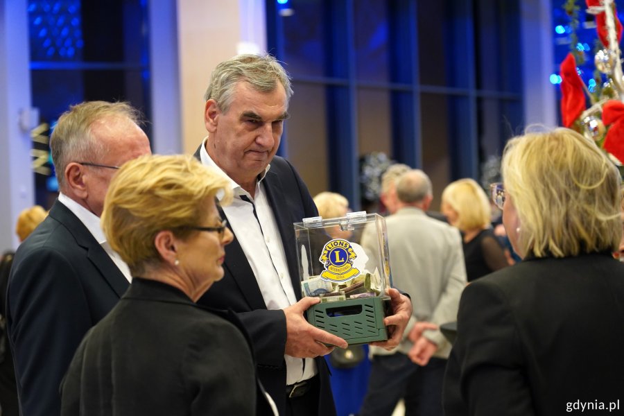 Uczestnicy wydarzenia oraz mężczyzna zbierający datki dla Lionc Club Gdynia