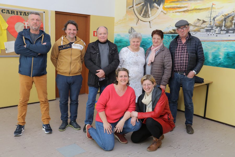 Na zdjęciu grupa osób. Stoi w górnym rzędzie od lewej trzech mężczyzn, dyrektor ZSP nr 5, pani Zofia Kuchta, kucharka z tejże szkoły oraz jeszcze jeden mężczyzna. W dolnym rzędzie klęczy była pani burmistrz Le Faou oraz pani Ewa.
