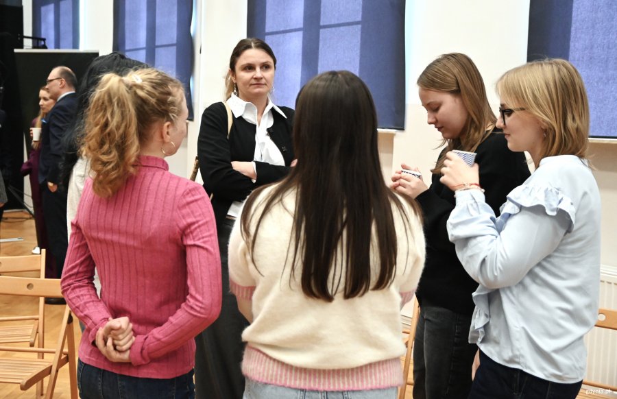 Młodziez skupiona wok&oacute;ł kobiety w kostiumie