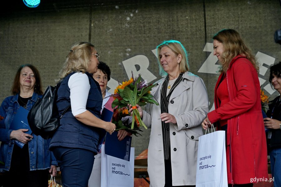 Beata Zastawna &ndash; przewodnicząca Rady Miasta Gdyni i Hanna Niedźwiecka-Pasternak &ndash; zastępca naczelnika Wydziału Ogrodnika Miasta wręczają nagrodę jednej z uczestniczek konkursu &bdquo;Gdynia w kwiatach&rdquo;  