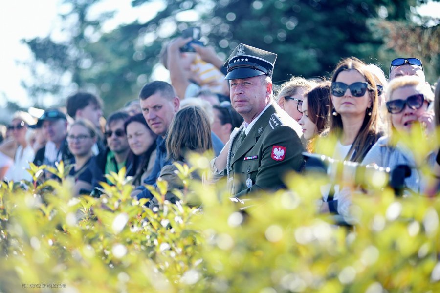 Tłum ludzi, na pierwszym planie mężczyzna w mundurze