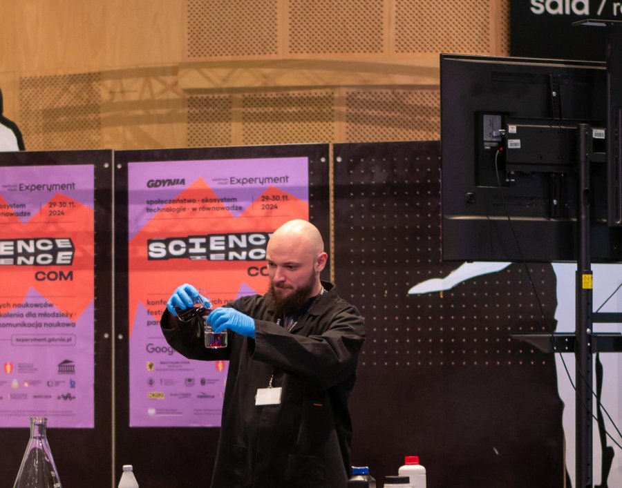 Mężczyzna demonstruje eksperyment podczas spotkania w Centrum Nauki Experyment