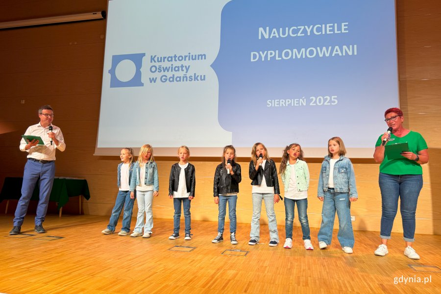 Osoby na scenie pozujące do zdjęcia po wręczeniu nominacji