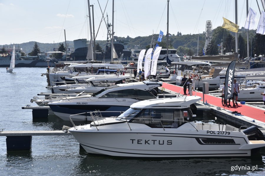 Różnego rodzaju jachty są zacumowane przy kei w Marina Yacht Parku w Gdyni. Na kei ludzie oglądający łodzie // fot. Magdalena Czernek