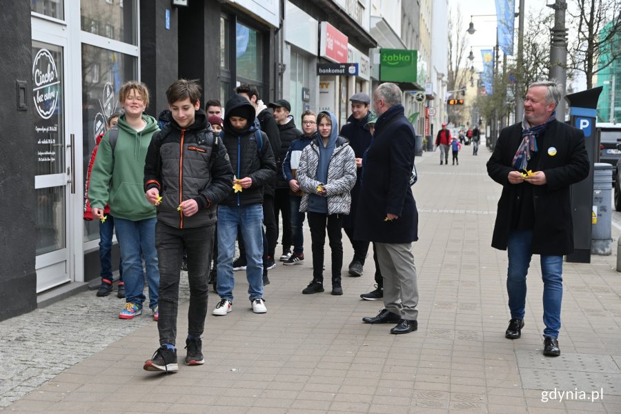 Młodzież na ulicach miasta rozdająca żonkile pamięci