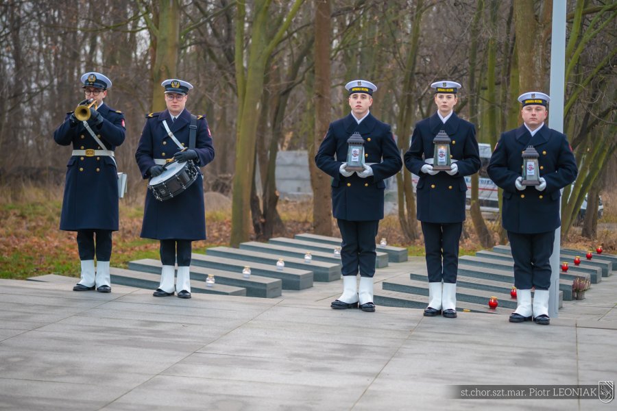 Trębacz, werblista oraz marynarze ze zniczami w rękach podczas uroczystości upamiętniających marynarzy represjonowanych przez władze komunistyczne w okresie powojennym