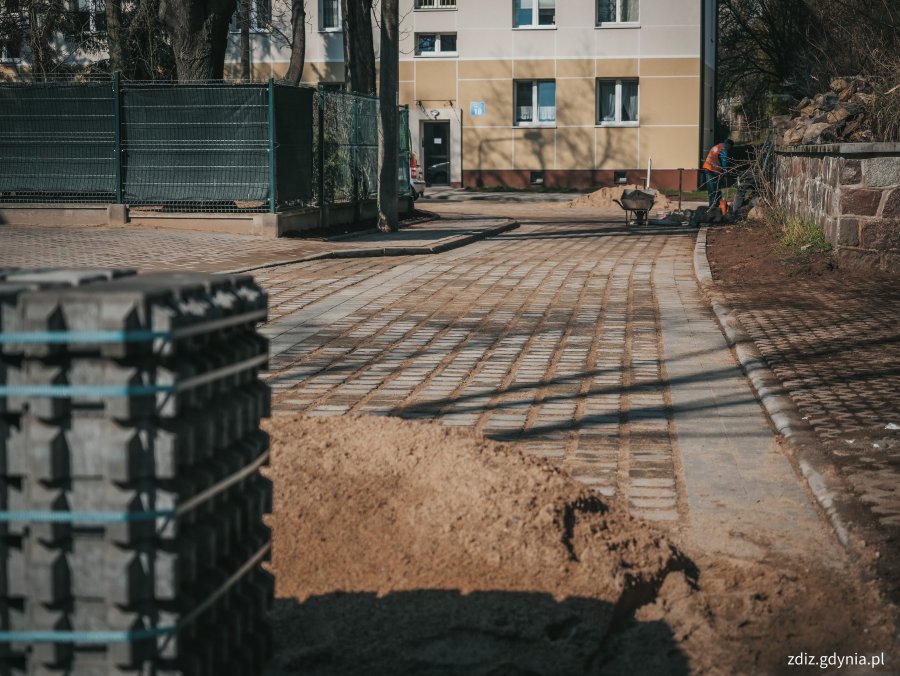 trwa układanie nawierzchni z kostki, na pierwszym planie kostka betonowa