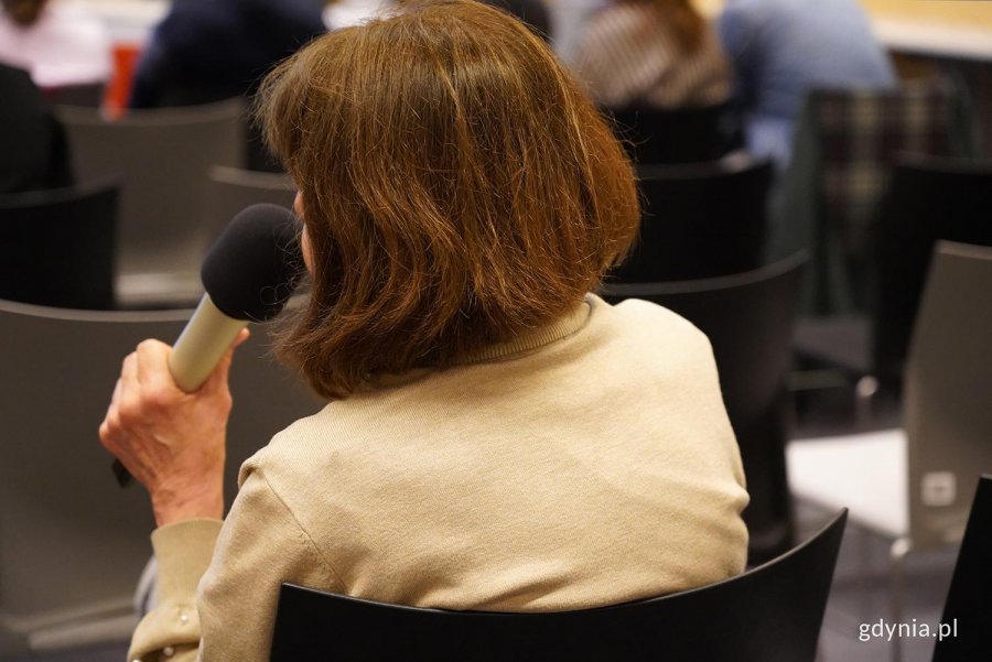 ludzie na sali podczas spotkania zabierają głos