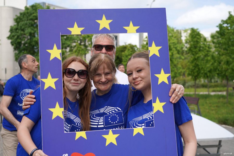 Trzy osoby w ramce do robienia zdjęć z emblematami UE