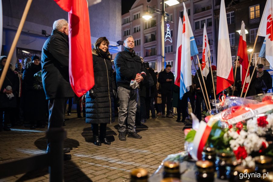 Grupa osób stojących przed pomnikiem