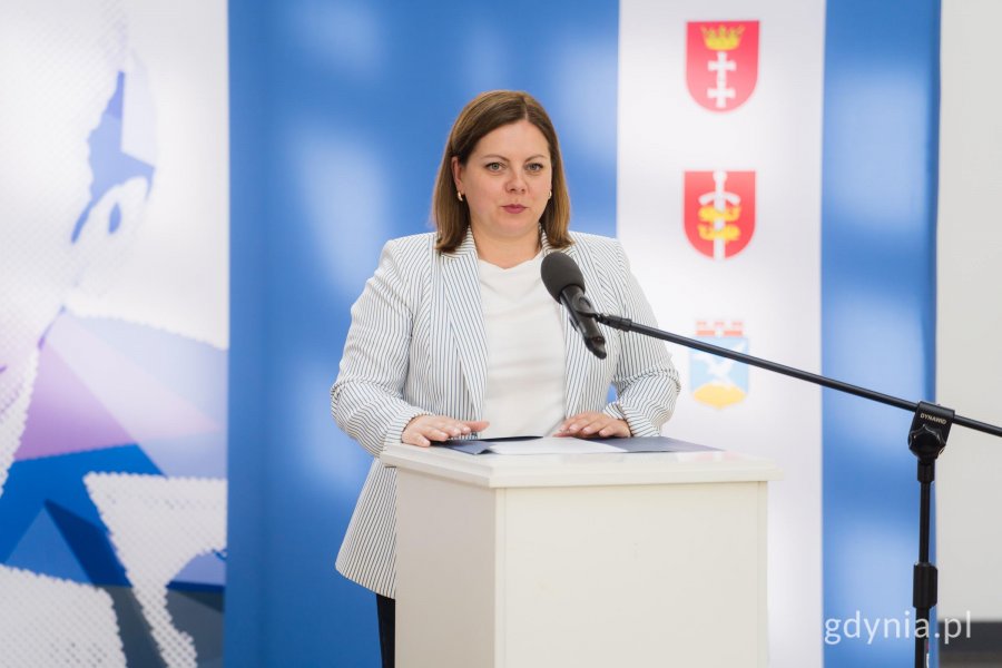 Kobieta w jasnej marynarce z mikrofonem