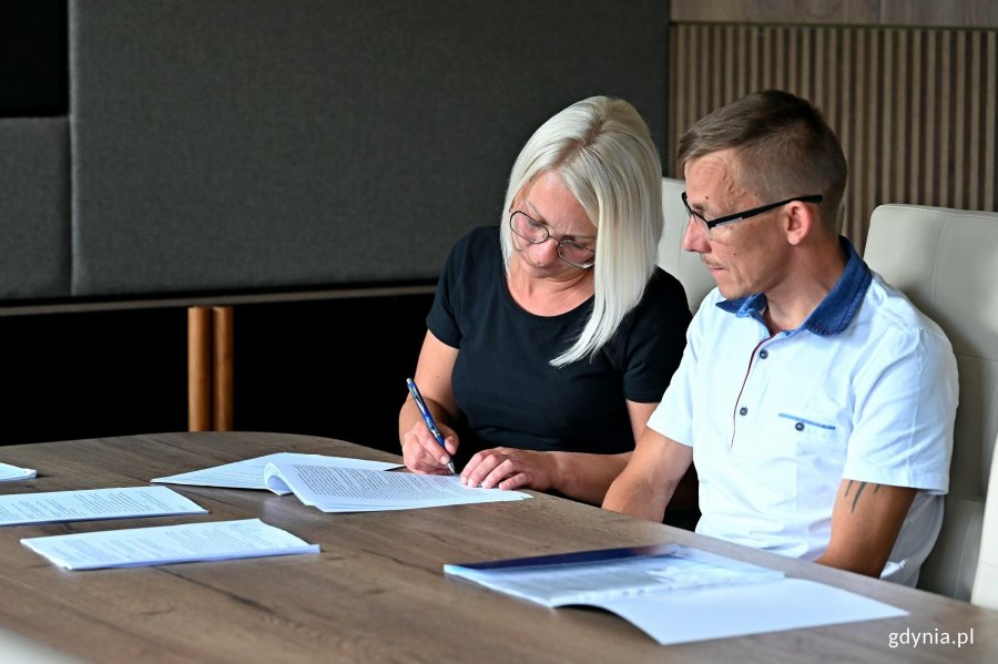 Patrycja i Patryk Baranowscy, uczestnicy programu &bdquo;Mieszkanie za remont&rdquo;, podczas podpisywania umowy 
