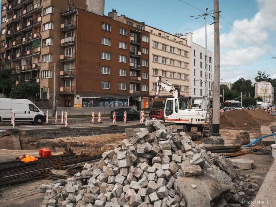 trwająca budowa, widoczna kostka brukowa, roboty, w tle budynki i ruch uliczny