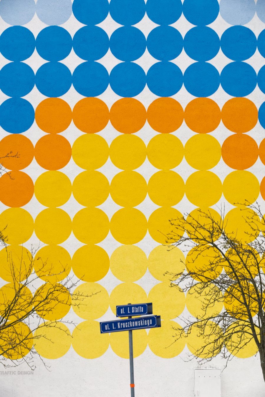 Kolorowe koła na ścianie jednego z blok&oacute;w na Karwinach układające się we wsch&oacute;d słońca nad morzem