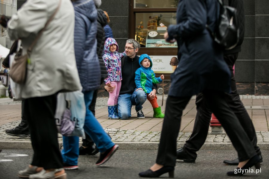 Wielobarwny Pomorski Przemarsz Seniorów ulicami Gdyni. Paradę ogląda mężczyzna z dwójką dzieci. Fot. Karol Stańczak