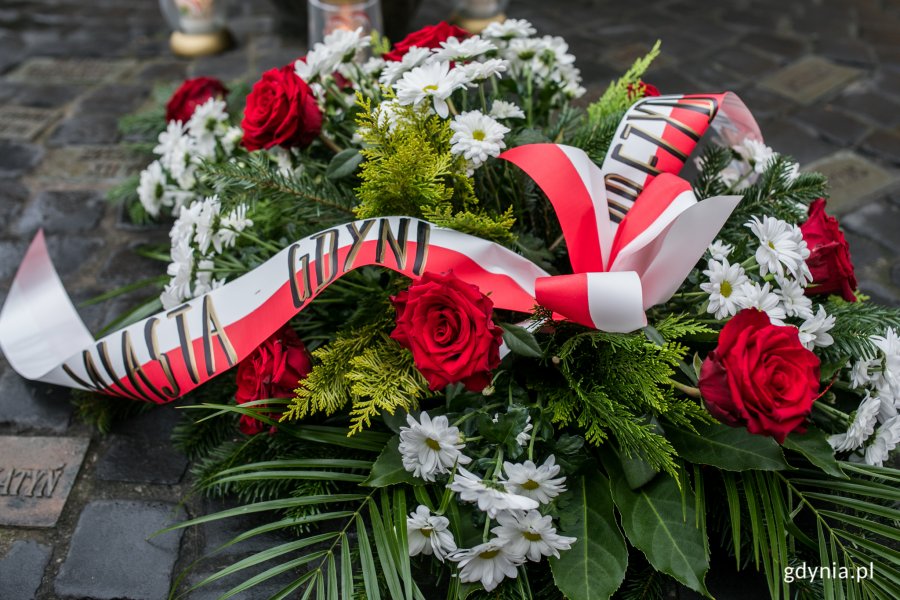 Wieniec z czerwonych róż i białych margaretek oraz zielonych liści złożony pod pomnikiem Ofiar Terroru Komunistycznego w 39. rocznicę wprowadzenia stanu wojennego. Na górze wiązanki umieszczono biało-czerwoną szarfę //fot. Karol Stańczak