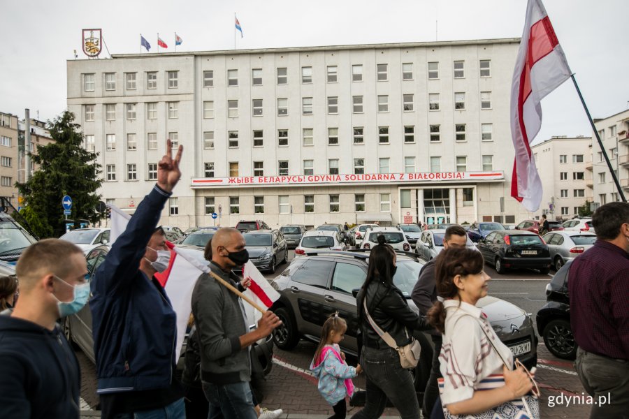 Uczestnicy akcji "Stop przemocy przeciwko narodowi Białorusi" idą al. Marsz. Piłsudskiego w Gdyni. Niektórzy z nich w rękach niosą białoruskie flagi // fot. Karol Stańczak