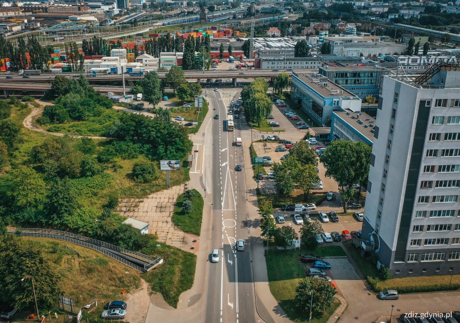 widok z góry na ulicę, widoczny ruch uliczny, budynki w tle