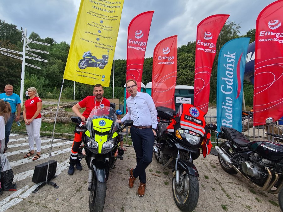 W 16. edycji Moto Safety Day uczestniczył Jakub Ubych - wiceprzewodniczący Rady Miasta Gdyni (pierwszy z prawej). Na zdjęciu przy motocyklach z ratownikami ze stowarzyszenia Motopozytywni Trójmiasto. W tle powiewają flagi stowarzyszenia oraz spółki Energa // fot. materiały prasowe