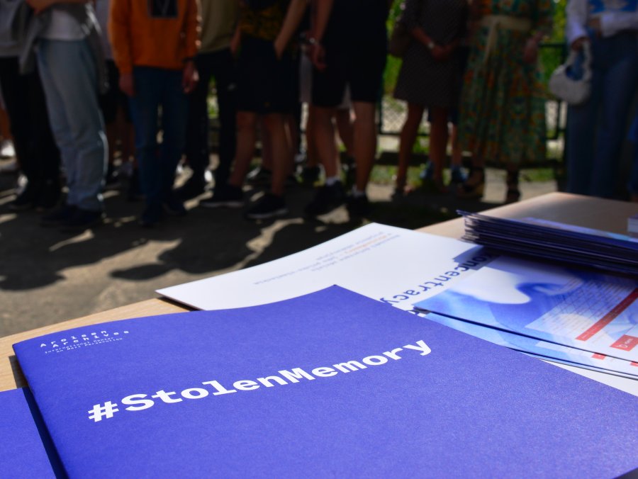 Ławka z materiałami edukacyjnymi o projekcie, w tle publicznośc wystawy