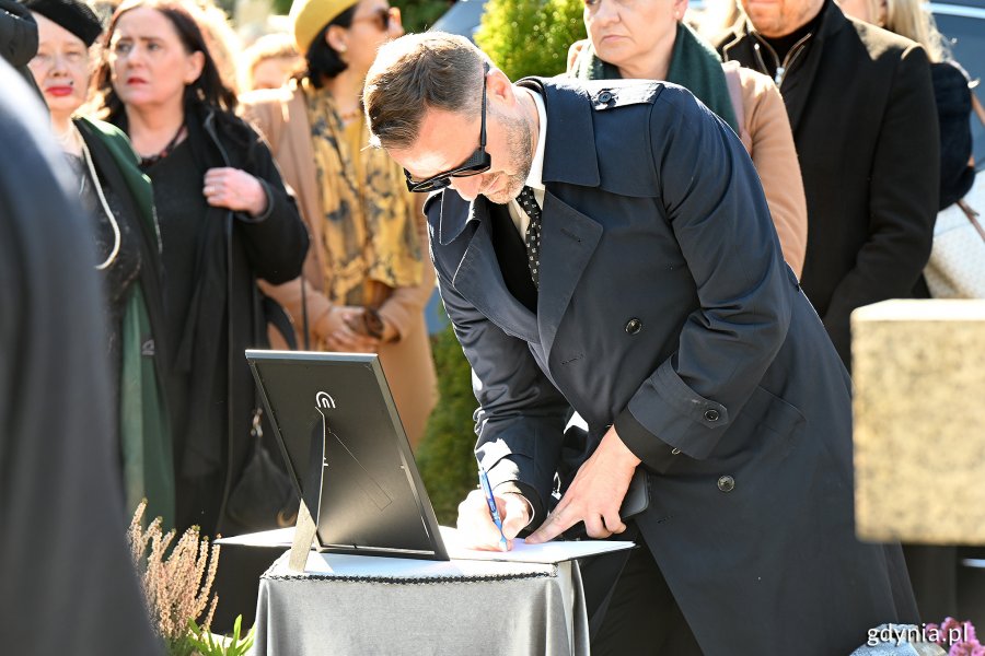 Uczestnicy uroczystości wpisujący się do księgi kondolencyjnej Leszka Kopcia na Cmentarzu Łostowickim w Gdańsku (fot. Michał Puszczewicz)