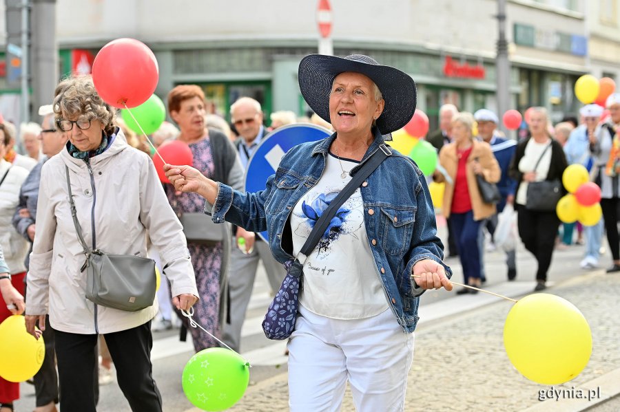 Uczestnicy przemarszu w ramach V Pomorskiego Dnia Seniora. W rękach trzymają kolorowe balony