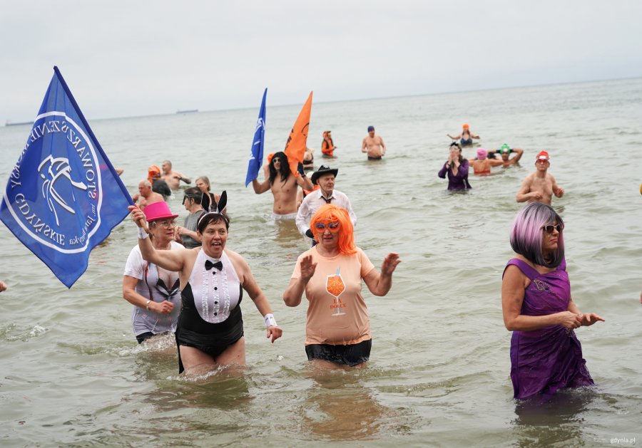 Grupa os&oacute;b w morzu w kolorowych strojach