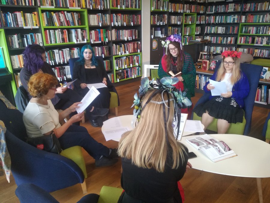 Uczestnicy Narodowego Czytania w Bibliotece z Pasją siedzą w fotelach ustawionych przy stołach // fot. materiały prasowe