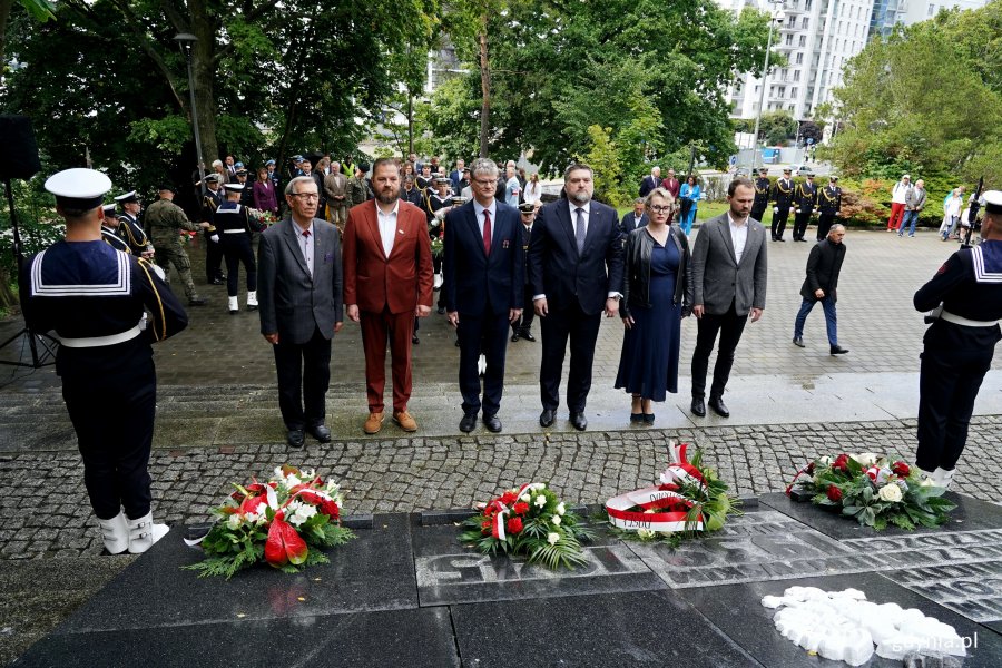 Delegacja gdyńskich samorządowc&oacute;w składająca kwiaty podczas uroczystości  z okazji 87. rocznicy wybuchu II wojny światowej na Cmentarzu Wojennym w Redłowie. Od prawej: radni miasta Norbert Anisowicz i Agnieszka Tokarska, Tadeusz Szemiot &ndash; przewodniczący Rady Miasta Gdyni, wiceprezydent Rafał Geremek, radny miasta Łukasz Strzałkowski oraz były radny Zenon Roda 